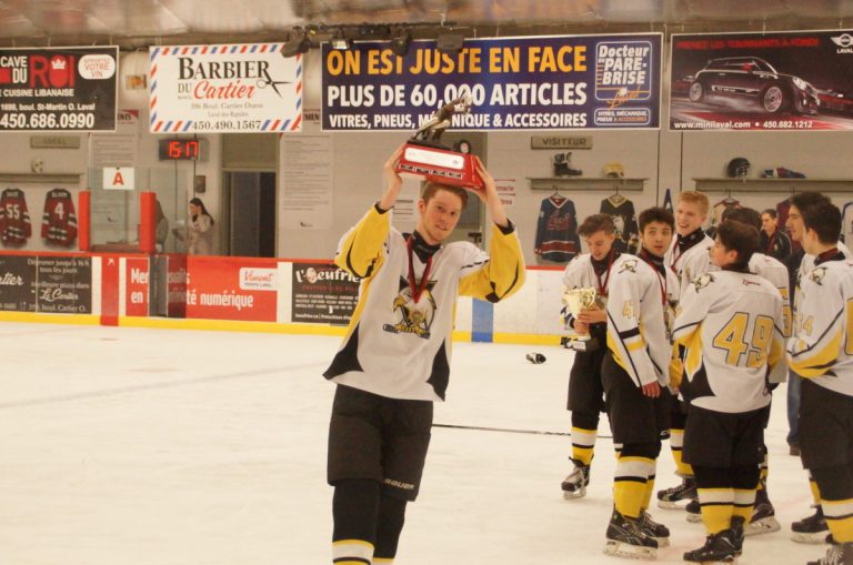 Mathieu Grenier, des Bruins de Delta, soulève le trophée des champions de la classe A au Tournoi de l'Express de Laval.  Il a amassé une passe sur le but vainqueur.