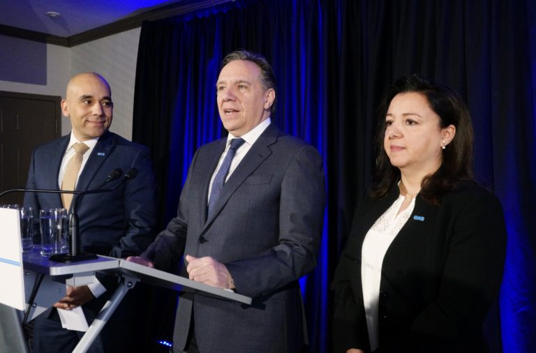 Christopher Skeete, candidat dans Sainte-Rose, ainsi qu'Alice Khalil, candidate dans Chomedey, entourent le chef de la Coalition Avenir Québec (CAQ) François Legault.