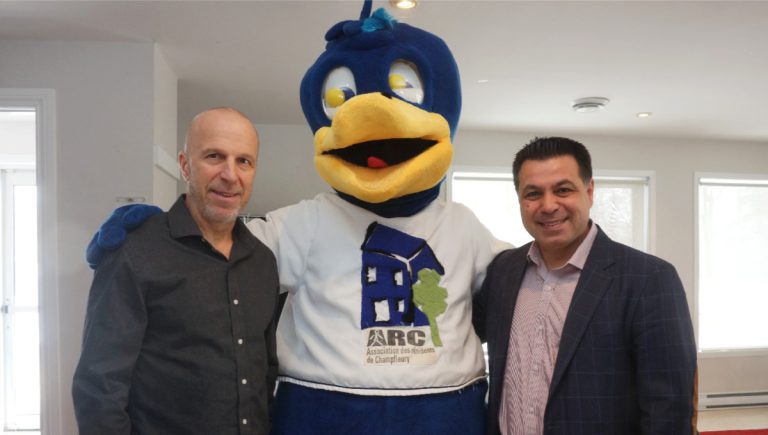 Paul-André Dagenais, président du conseil d'administration de l'ARC, et le maire suppléant, David De Cotis, posent en compagnie de la mascotte Fleu.