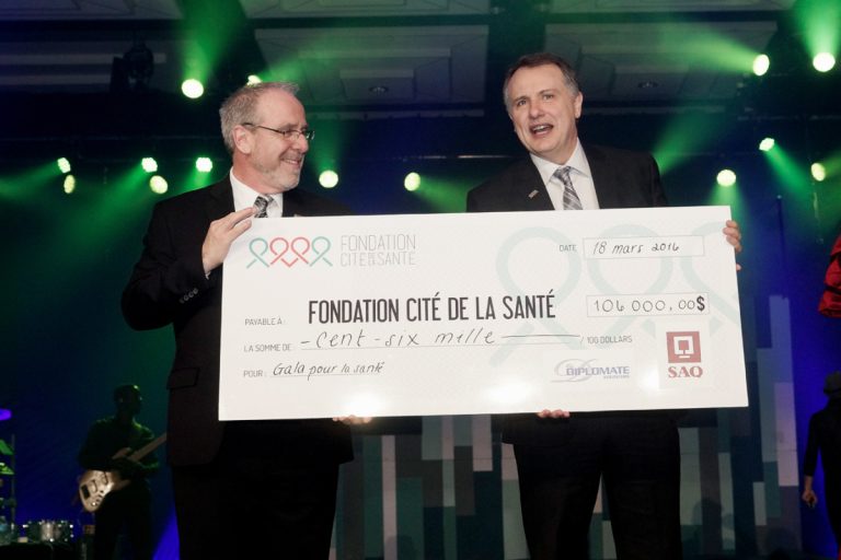 Alain Demers et Louis Gaudreau, respectivement directeur général et président du conseil d'administration de la Fondation Cité de la Santé, exhibent un chèque symbolique au montant de 106 000 $.