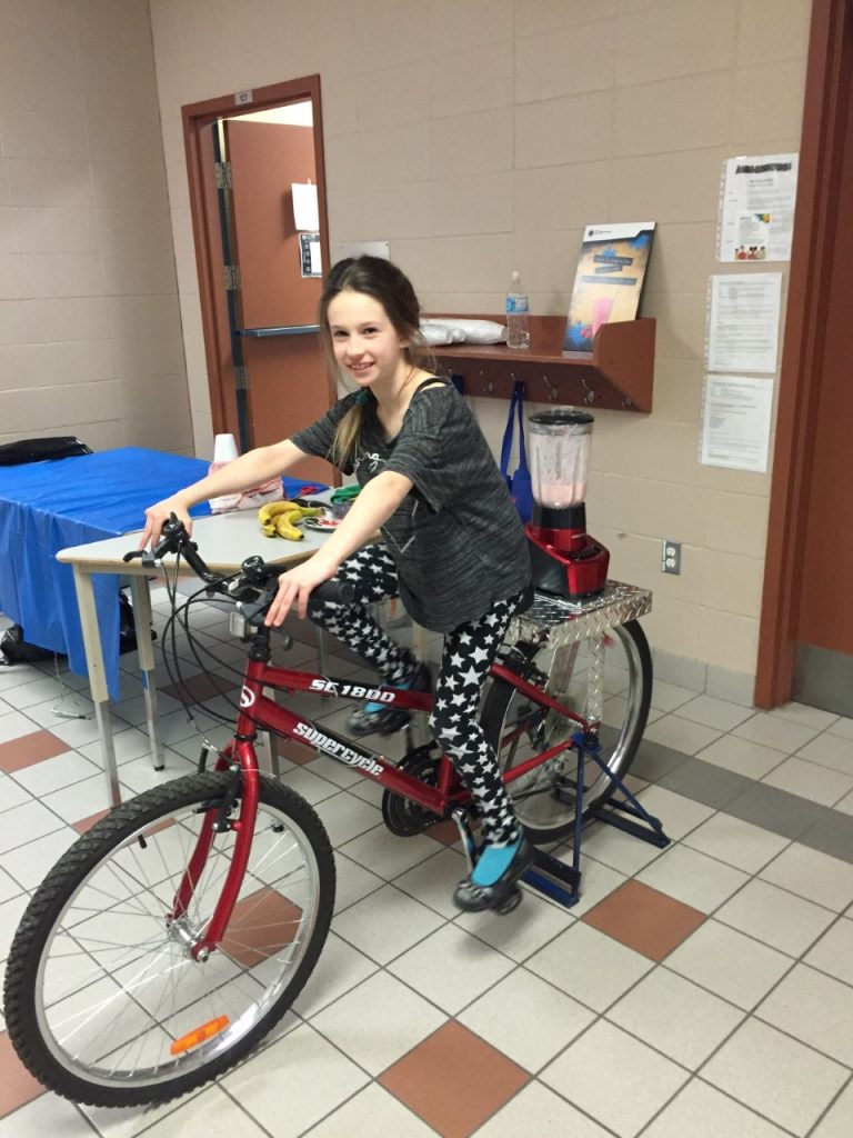 Kyara Courtemanche, élève de l'école l'Aquarelle, a essayé le vélo à smoothie lors d'une visite à l'établissement de Sainte-Rose.