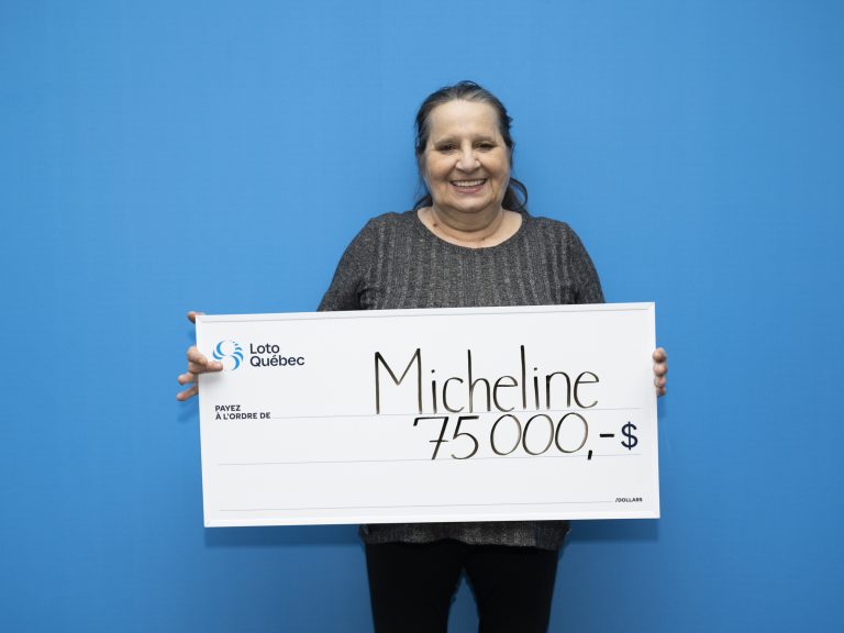 Micheline Théberge avec son chèque de 75 000$ remporté à l'aide d'un billet à gratter de Loto-Québec.