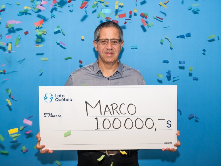Marco Steben avec son chèque de 100 000$ remporté grâce à un billet de Gagnant à vie.