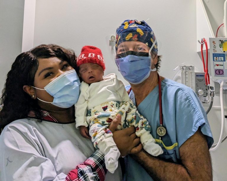 Le Dr François Lacombe avec la mère et le bébé de son 10 000e accouchement.