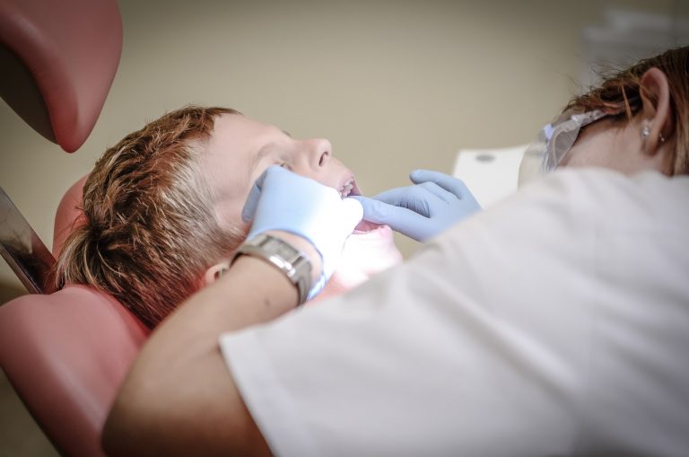 dentiste vérifiant la santé buccodentaire d'un jeune patient