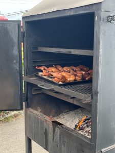Des poulets sont rôtis dans le fumoir chaque samedi aux Agneaux de Laval et disponibles pour emporter sous les nouvelles pergolas ou à la maison.(Photo 2M.Media – Geneviève Quessy) 