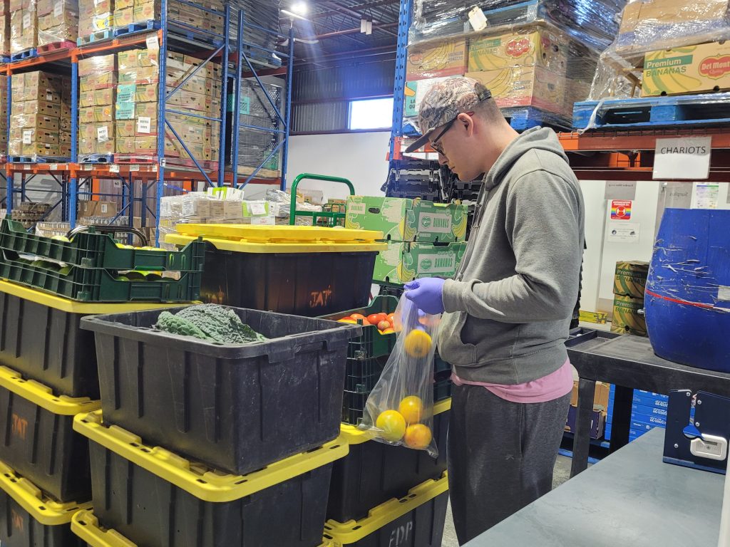 Les bénévoles sont déjà à l’ouvrage dans l’entrepôt du CBML pour poursuivre la distribution régulière d’aide alimentaire et préparer les paniers de Noël. (Photo 2M.Media – Corinne Prince)