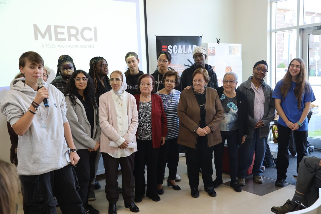 Taïsiia Dobrovolska au micro en compagnie de ses collègues membres du comité intergénérationnel. (Photo gracieuseté - Johny Kondakjian)