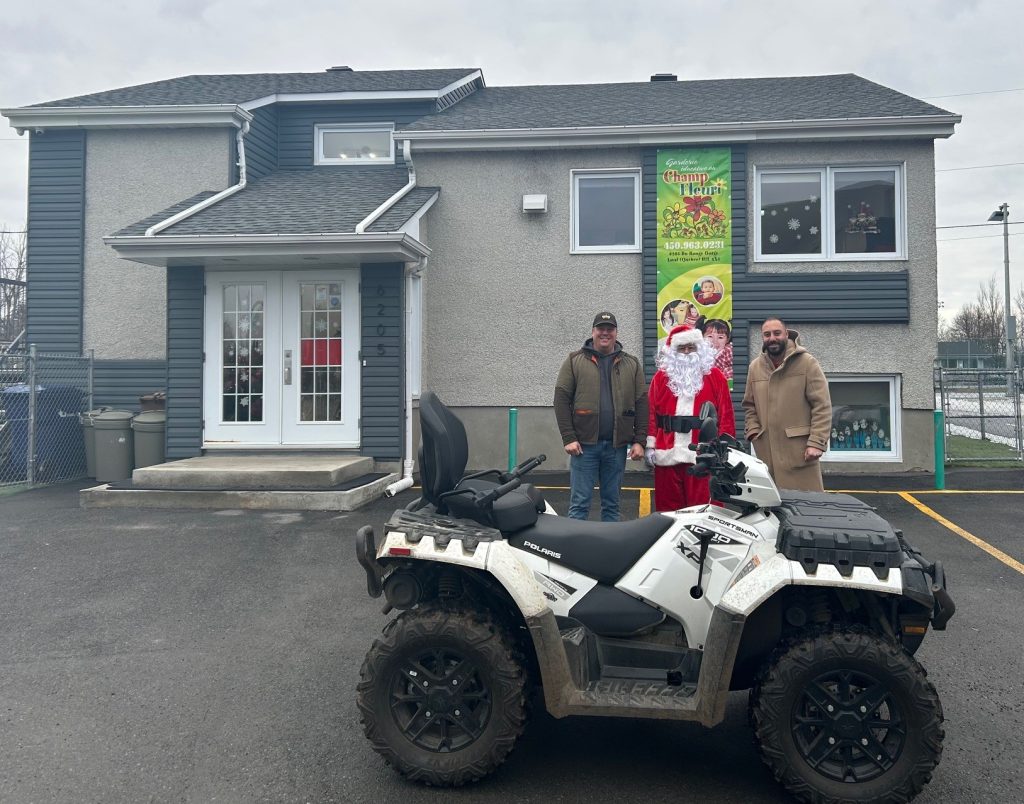 Dans l’ordre habituel: Philippe Deschamps, citoyen de Champfleury propriétaire du VTT, le père Noël et Chady Mourad, gestionnaire de la garderie Au Champ Fleuri. (Photo gracieuseté)