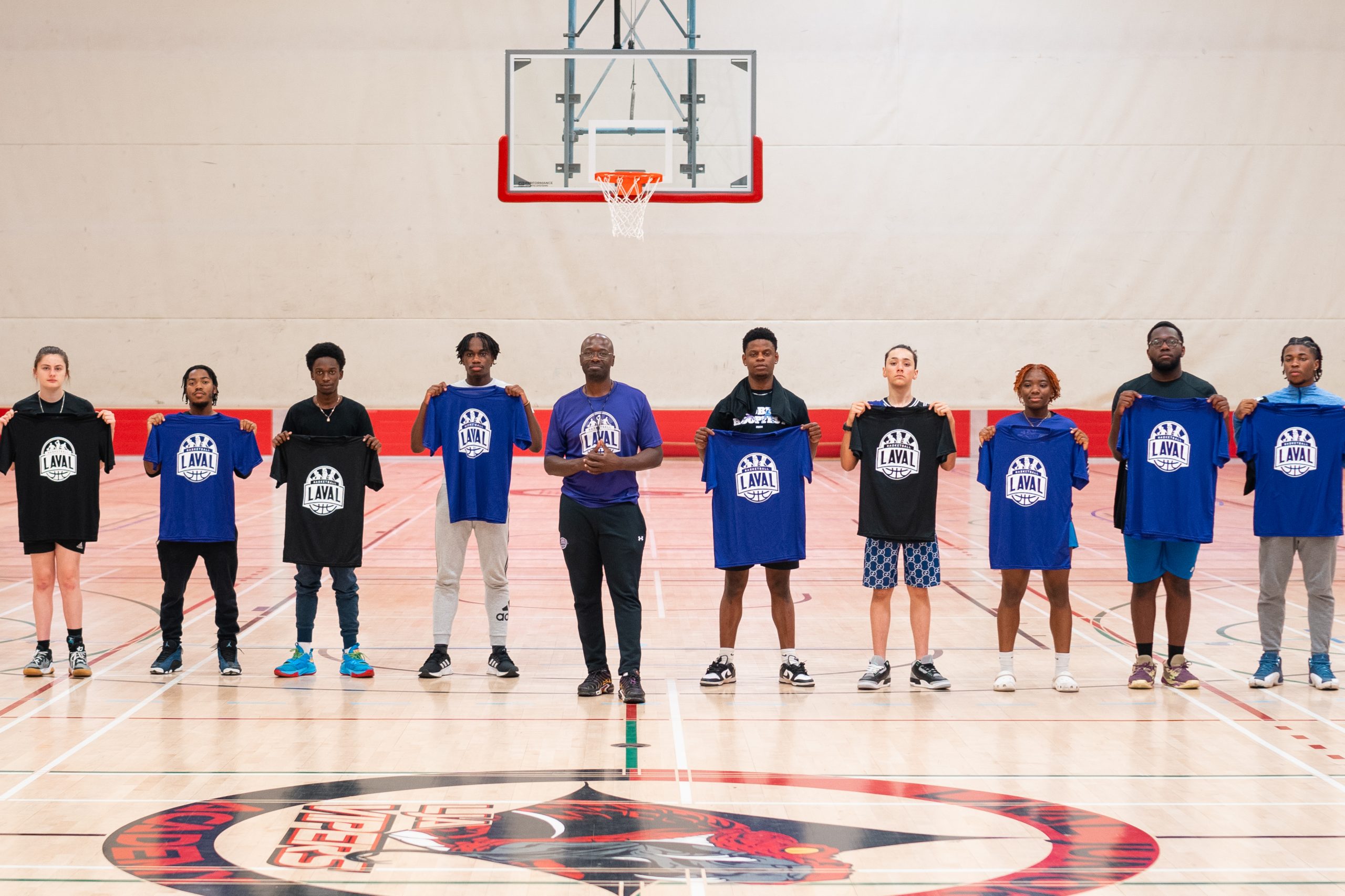 Éric Denis entouré de jeunes basketteurs ayant participé à l'initiative pour ensuite devenir entraîneurs-assistants.