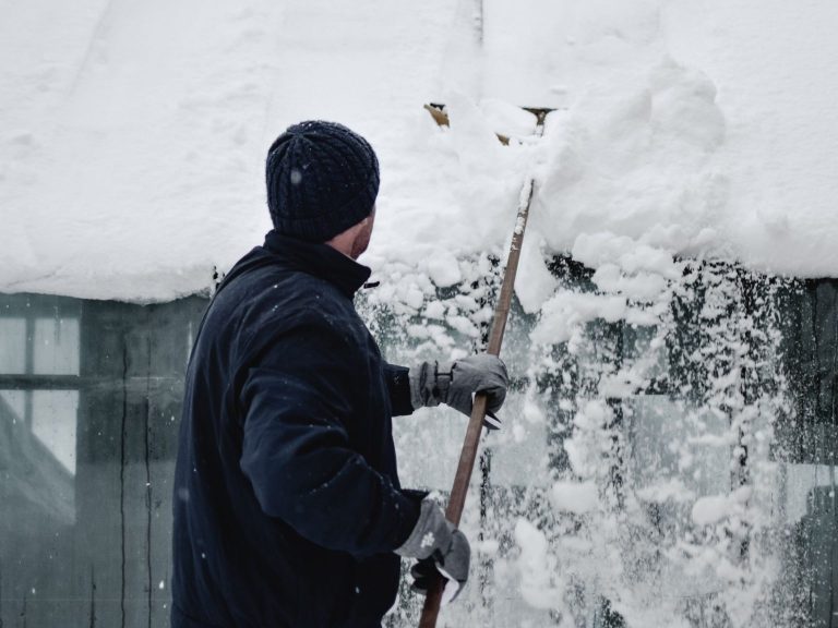 Personne qui déneige un toit.