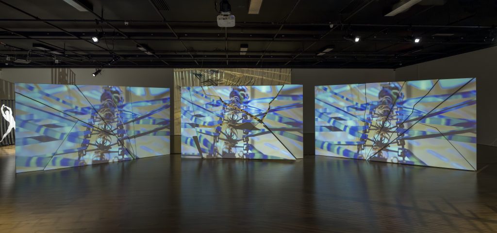 Une œuvre composée de massifs panneaux en polystyrène plaqués de fibre de bois animés trône dans la salle Alfred-Pellan et illustre la dichotomie entre un mur qui explose mécaniquement et la projection vidéo d’oiseaux qui s’envolent. (Photo gracieuseté - Guy L'Heureux)