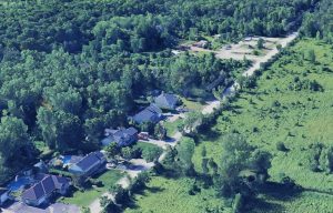 Les propriétaires des cinq résidences bordant le rang de l’Équerre déposaient en vain le 8 juillet une pétition de 24 signatures, réclamant la mise sur pause du projet de pavillon d’accueil au bois de l’Équerre et une consultation publique entourant ces nouvelles infrastructures municipales qu’ils souhaitaient plus modestes. Dans le coin supérieur droit de la photo se trouve l'aire de stationnement donnant accès au bois de l'Équerre.