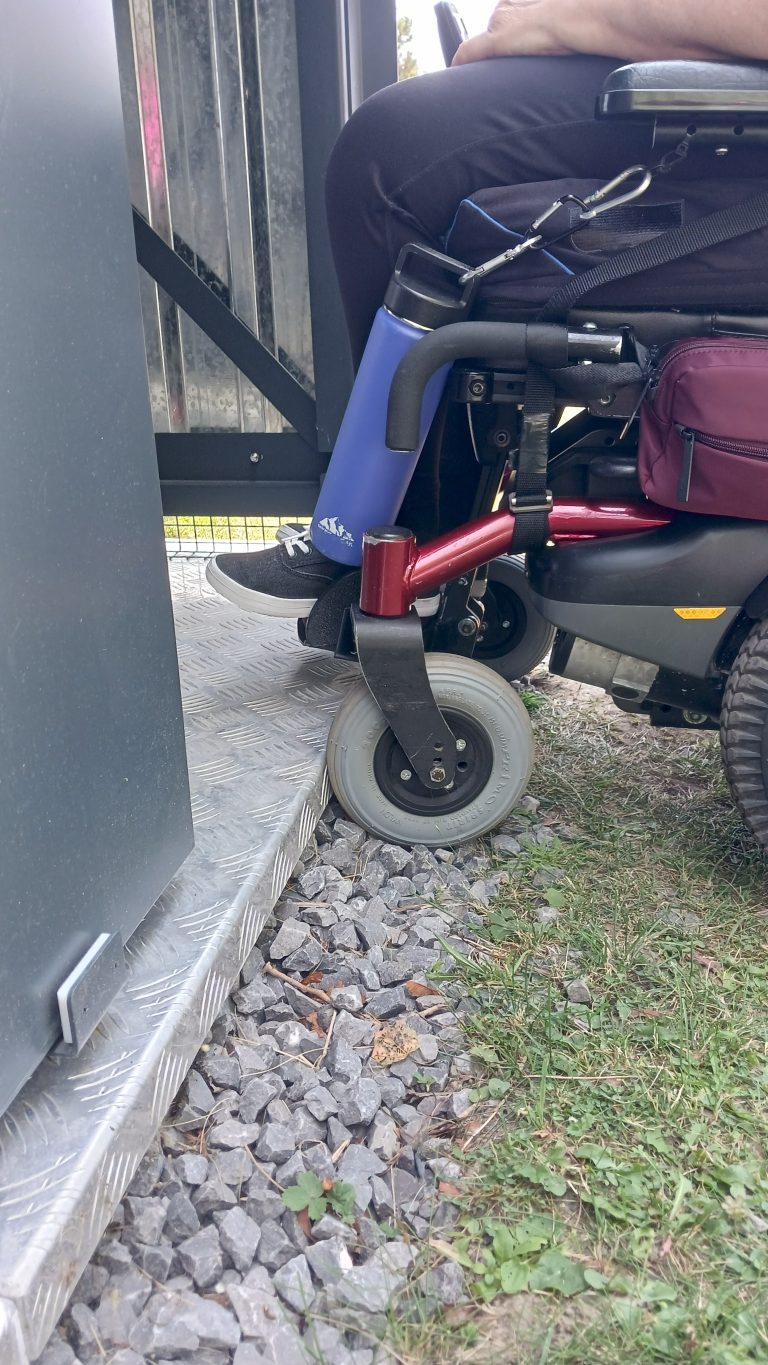 Une citoyenne en fauteuil roulant devant la toilette écologique située à la berge des Écores. (Photo gracieuseté)