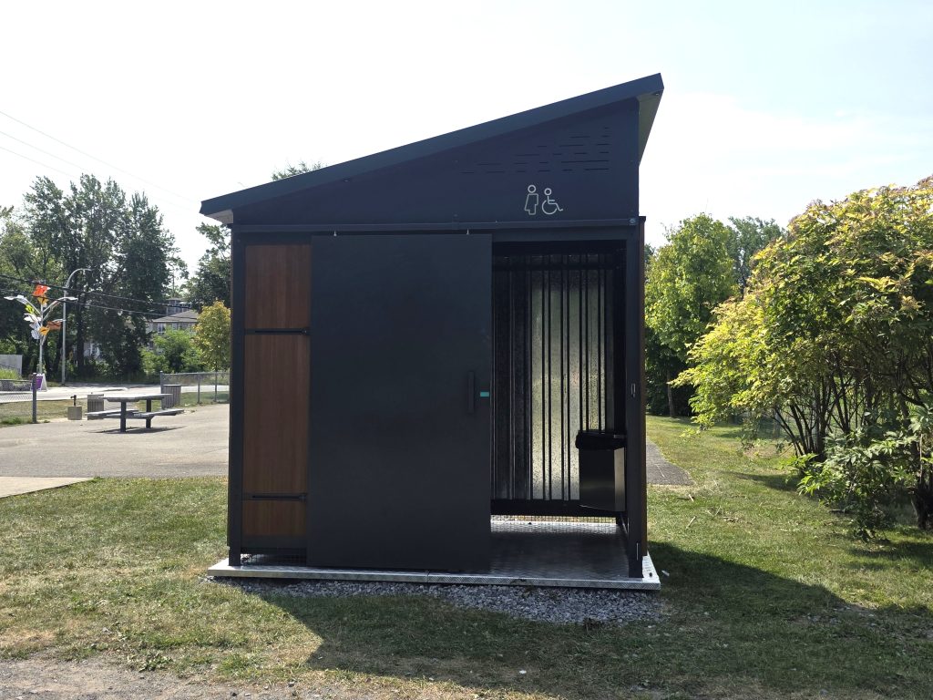 Aucun panneau n’informe les citoyen.ne.s que les petits bâtiments sont des toilettes, il n’y a que deux icônes sur leur façade avant. (Photo 2M.Media – Corinne Prince)