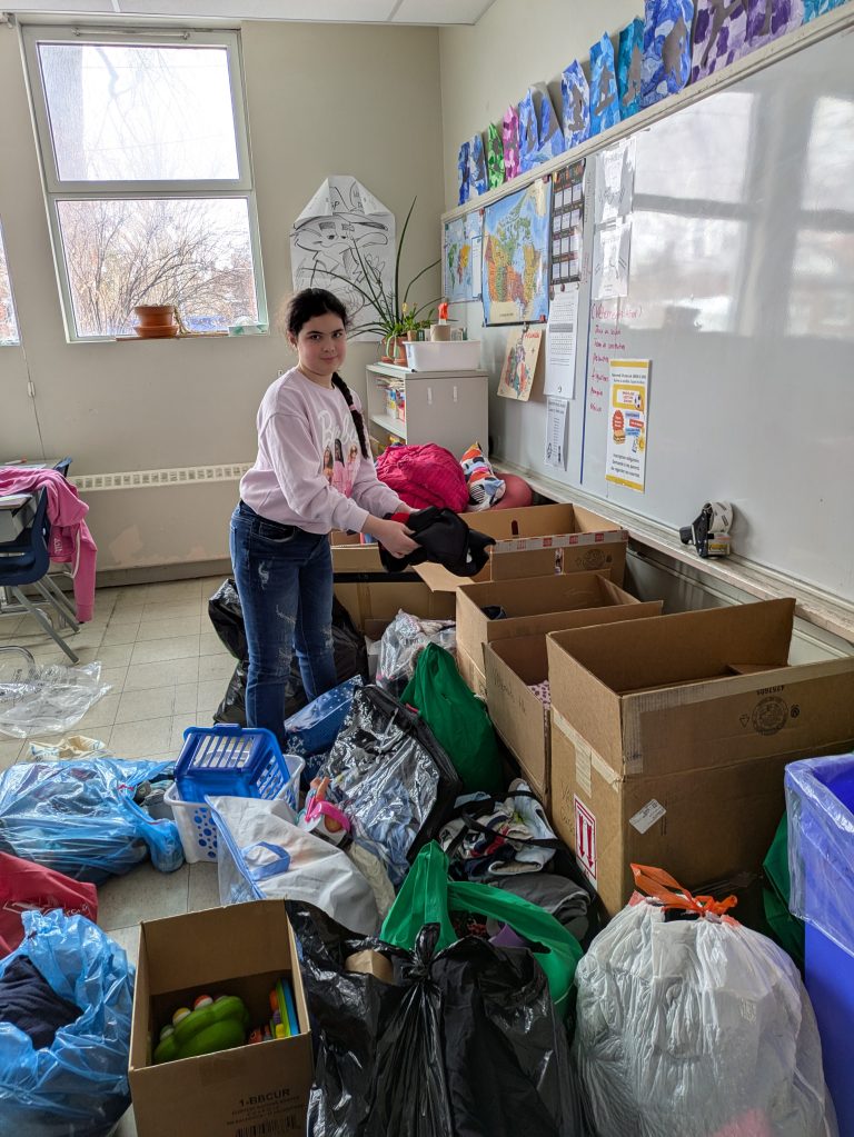 Émilie Emond affairée à trier les dons reçus par la communauté en vue de la friperie de l’école Léon-Guilbault. (Photo gracieuseté)