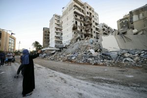 Une femme prend en photo l’immeuble détruit dans une attaque israélienne dans le sud de Beyrouth. (Gracieuseté- AFP)