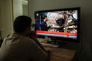 Un homme iranien regarde les informations à la télévision d’État iranienne à Téhéran, le 23 mars . (Photo gracieuseté-AFP) 
