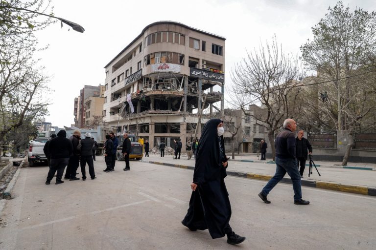 Des personnes marches vers les dégâts d'une frappe de missile survenue à Téhéran, Iran le 29 mars.( Photo gracieuseté-AFP)
