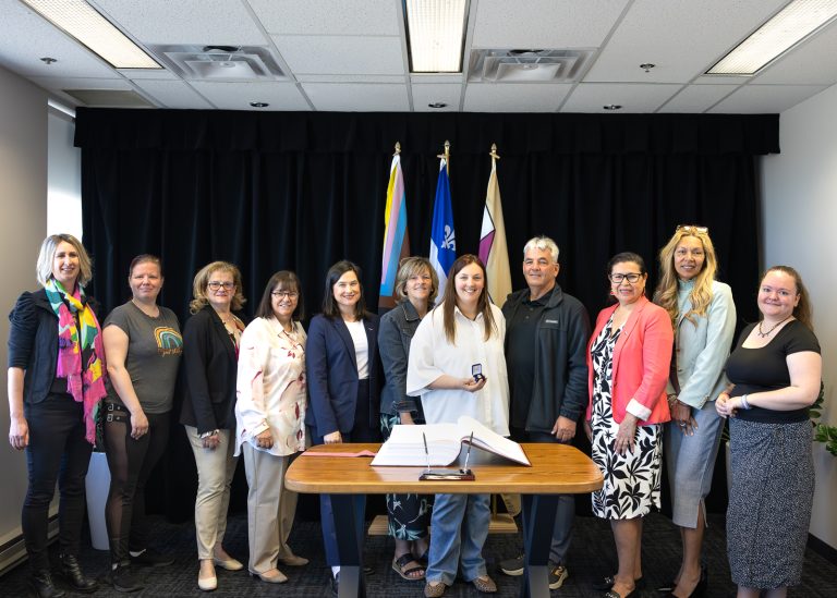 Maude St-Germain entourée de plusieurs élues et personnes du milieu communautaire lavallois lors de sa signature du livre d'or de la Ville. (Photo gracieuseté)