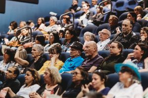 Tandis que les participants s’installaient, les noms d’organismes communautaires lavallois défilaient à l’écran. (Photo gracieuseté — Olivia Photography)