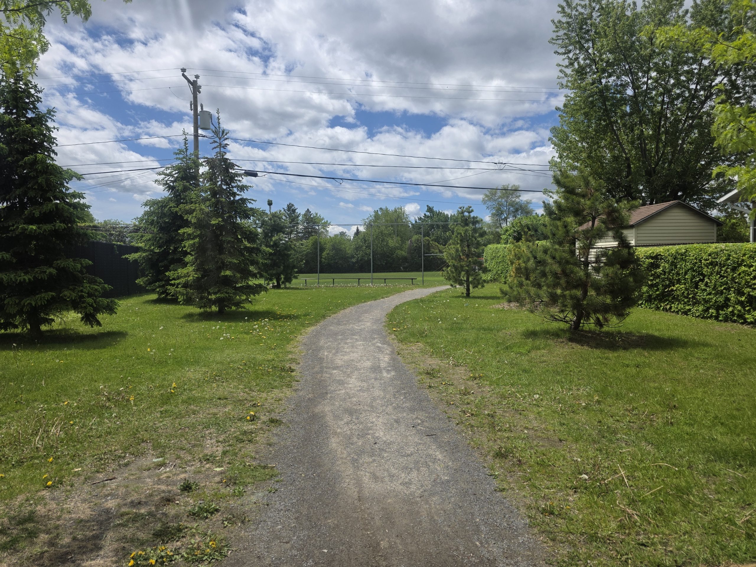 Le sentier du parc-école Saint-François est actuellement fait de petit gravier et partagé par piétons et cyclistes. (Photo 2M.Media – Corinne Prince)