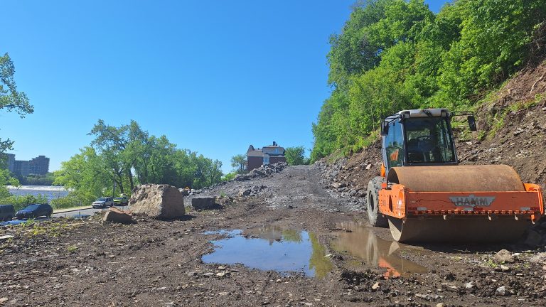 Lors de notre passage sur le chantier déserté de la rue du Barrage, il ne restait plus qu’un rouleau compacteur au pied de la falaise.