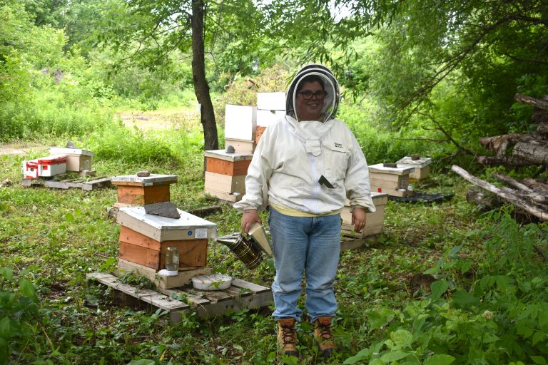 La SAPIQ sensibilise Laval au déclin des abeilles et pollinisateurs Mélodie Boivin, présidente de la SAPIQ, au milieu des ruches. (Photo 2M.Media – Emmanuelle Froment)